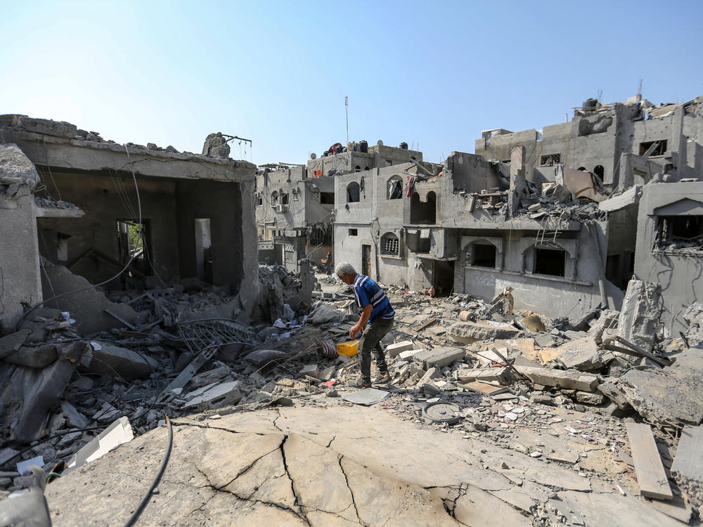 A local citizen searches through buildings which were destroyed during Israeli air raids in the southern Gaza Strip on Monday in Khan Younis, Gaza.