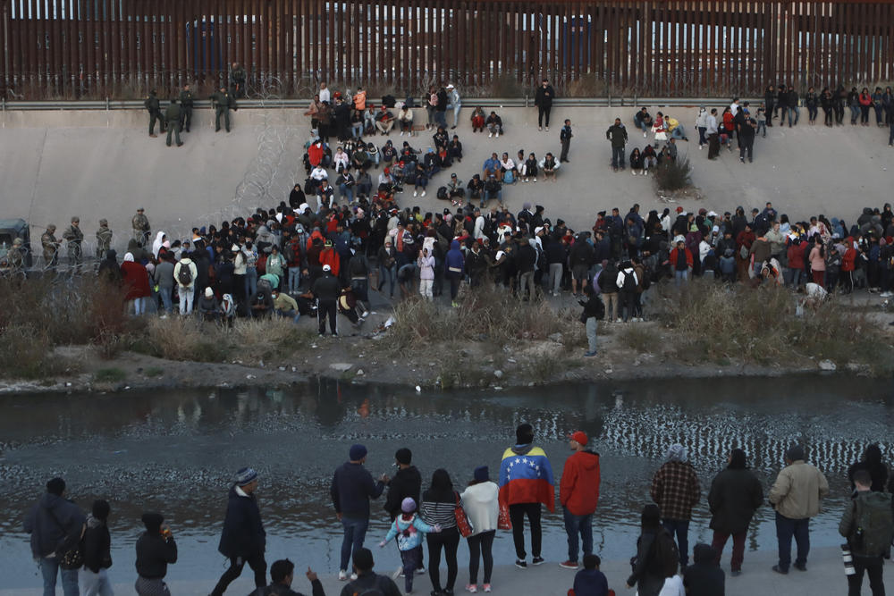 Migrants gather at a crossing into El Paso, Texas, as seen from Ciudad Juárez, Mexico, Dec. 20, 2022.