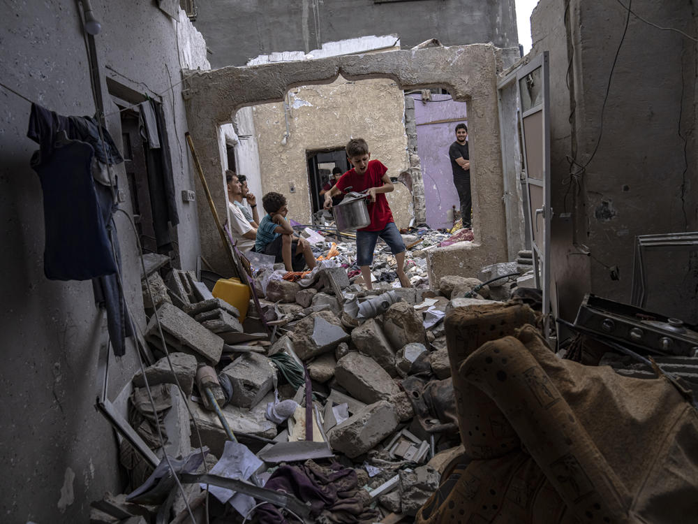 Palestinians inspect the rubble of a house after it was struck by an Israeli airstrike in Khan Younis, southern Gaza Strip on Sunday.