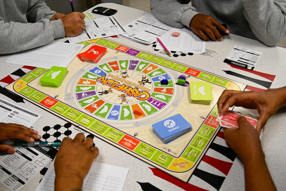Youths incarcerated at the Baltimore City Juvenile Justice Center play a board game as part of a financial literacy presentation.