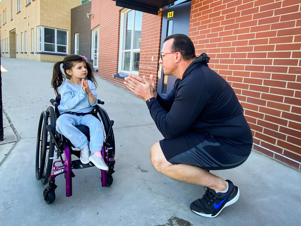 John Opp and his daughter Giuliana communicate with their hands at the Isabella Bird Community School in Denver. Opp said he's grateful for the universal pre-K program and the support it provides her.