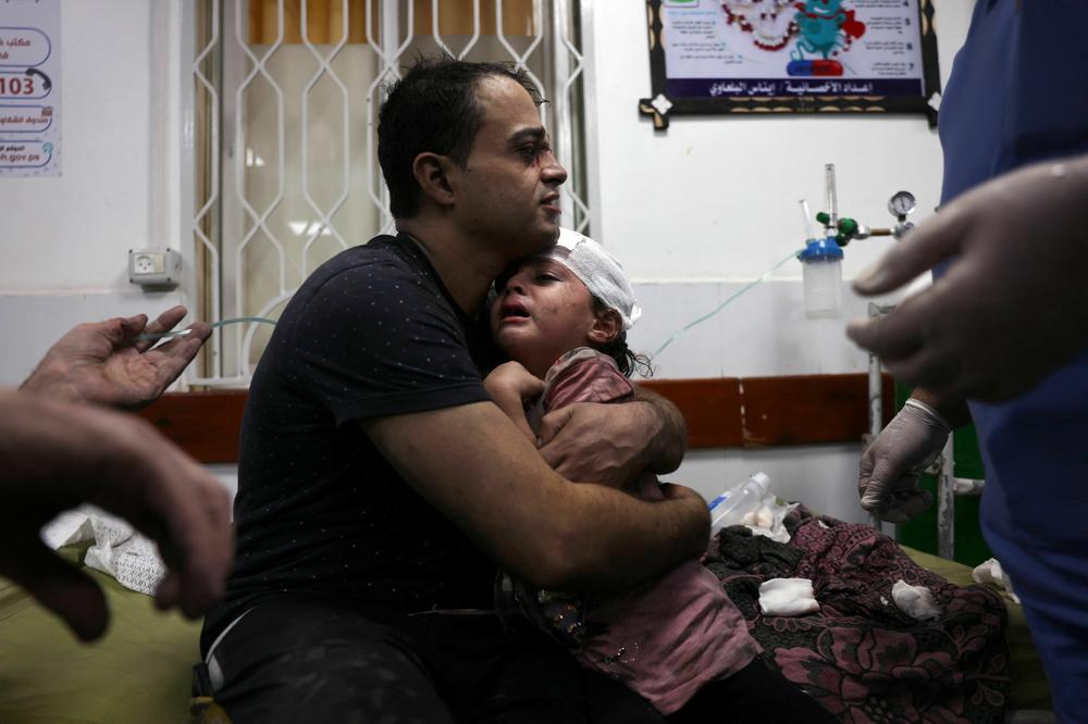 A Palestinian man cradles a injued child at the Najjar hospital following an Israeli air strike on a home in Rafah, in the southern Gaza Strip on October 30.