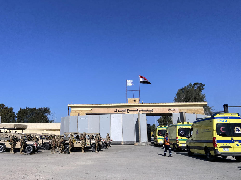 Ambulances wait to cross the border near Rafah to treat injured people in Gaza on Monday.