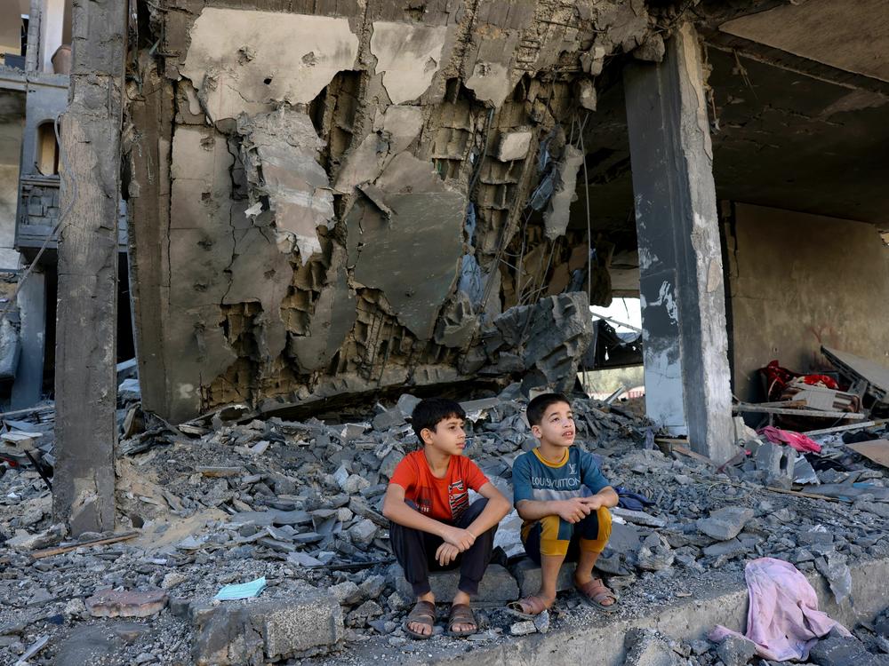 Children sit amid the rubble of a building in the aftermath of an Israeli strike in Rafah in the southern Gaza Strip on Friday.