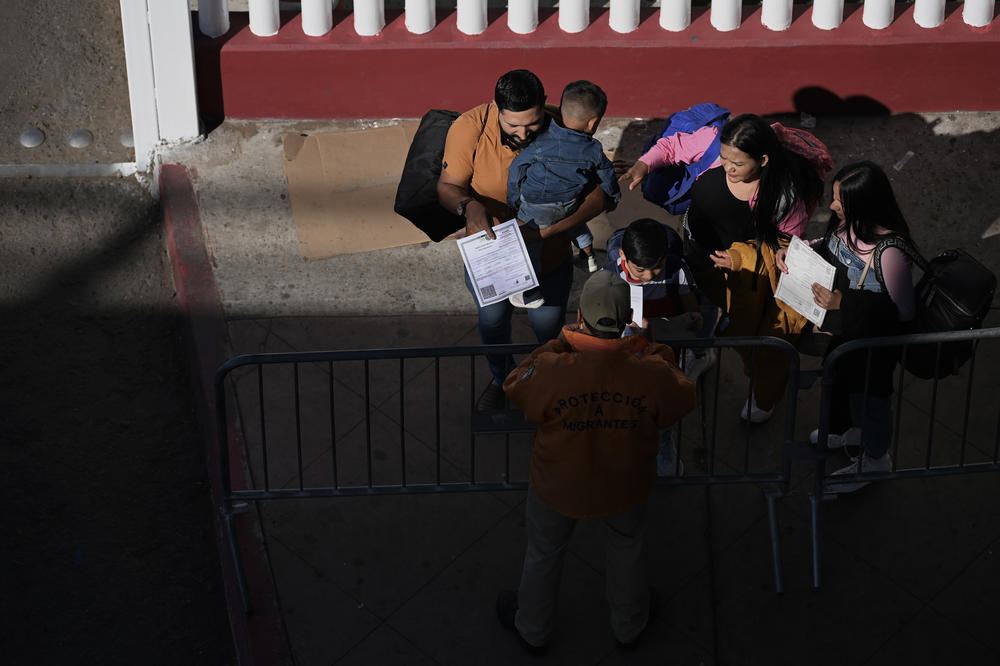 A migrant family shows their paperwork to Mexican immigration officials to proceed with their CBP One asylum appointments at the Chaparral pedestrian border in Tijuana, Mexico, to cross to the U.S. on Thursday.