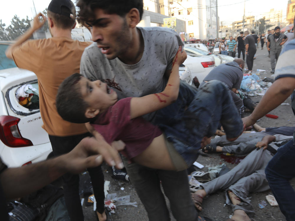 An injured Palestinian boy is carried away in the aftermath of an Israeli airstrike outside the entrance of the al-Shifa hospital in Gaza City on Nov. 3. Israel said it targeted Hamas members using an ambulance to leave the hospital. Hamas denied this. Hospital officials said 13 people were killed and dozens injured.