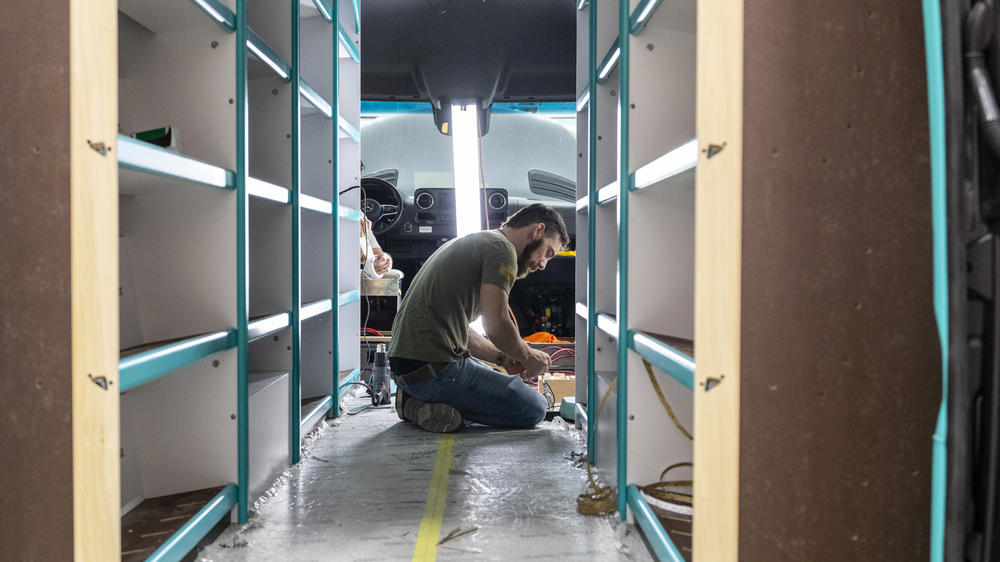 An Advanced RV employee works on a custom RV that will eventually become a mobile library.