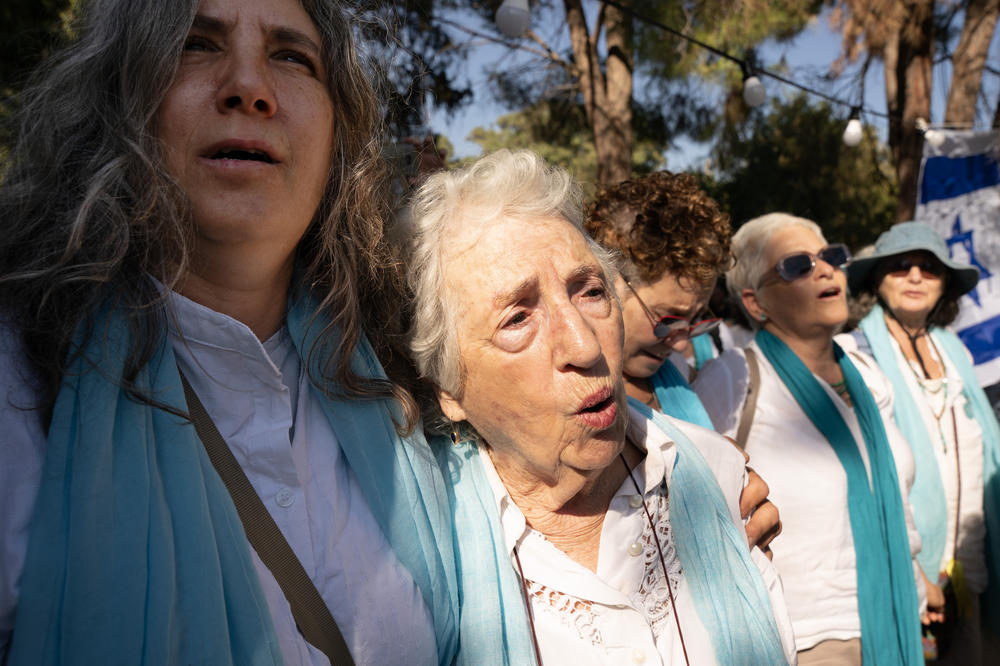 Members of the Women Wage Peace organization sing together as hundreds of mourners gather for the funeral service Thursday.