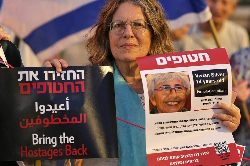 A demonstrator holds a poster showing Israeli Canadian Vivian Silver, who was missing and was presumed to be held by Palestinian militants since Hamas' Oct. 7 attack, during a protest for her release outside the president's residence in Jerusalem on Oct. 29.