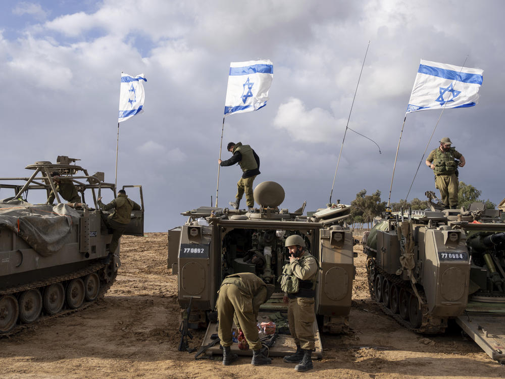 Israeli soldiers work on armored military vehicles along Israel's border with the Gaza Strip, in southern Israel, on Monday.