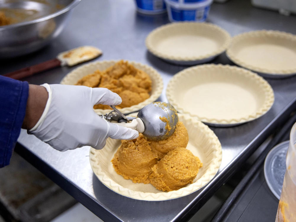 Chef Jones scoops globs of sweet potato mixture into shells of pie dough at Ol' Henry. Sweet potato pie is a significant touchstone of African American culture, especially around Thanksgiving.
