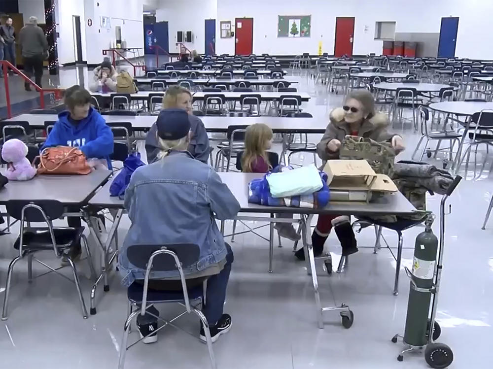 This image taken from video and provided by WTVQ shows people sitting at a table at Rockcastle Middle School which was being used as an evacuation center in Mt. Vernon, Ky., on Wednesday. Residents were evacuated after a CSX train derailed near Livingston, a remote town in Rockcastle County.