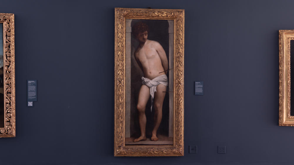 The work attributed to Titian hangs between two other paintings of Saint Sebastian in the gallery of Belen Jesuit Preparatory School in Miami.