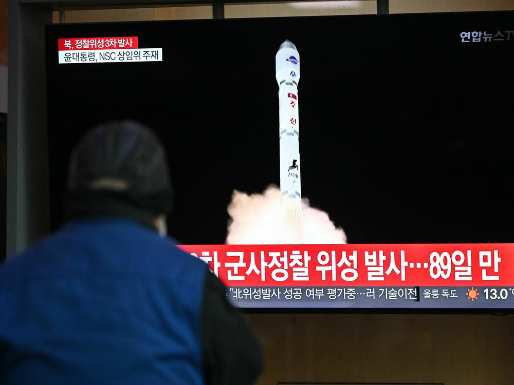 A man watches a television screen showing a news broadcast with a picture of North Korea's latest satellite-carrying rocket launch, at a railway station in Seoul on Nov. 22.