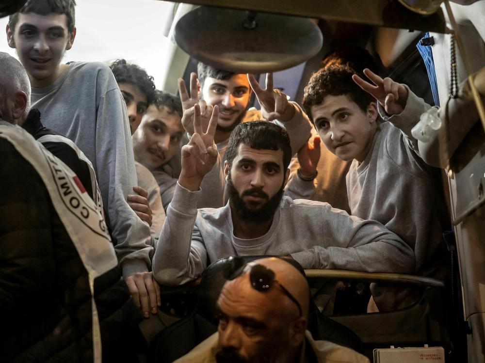 People gesture from a Red Cross bus carrying Palestinian prisoners released from Israeli jails in exchange for hostages released by Hamas from the Gaza Strip, in Ramallah, in the occupied West Bank, on Sunday.