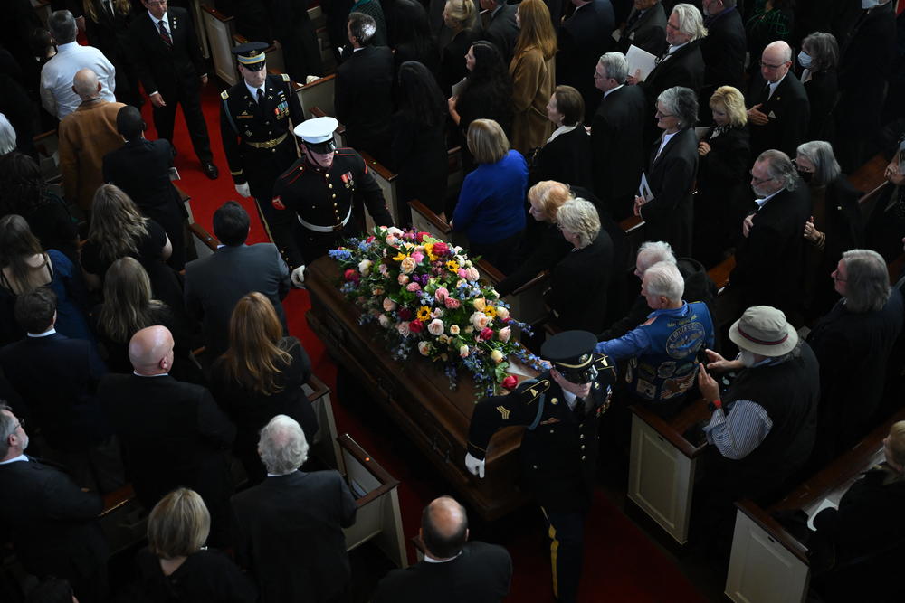 Attendees stand as the casket of former US First Lady Rosalynn Carter is carried out following a tribute service at Glenn Memorial Church in Atlanta, Ga, on Nov. 28, 2023.