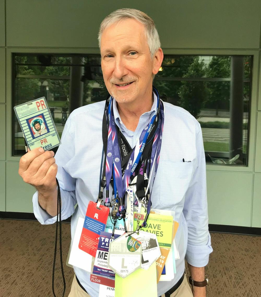 Dave Davies stands outside of the<em> Fresh Air</em> studio in Philadelphia with a collection of press passes from over the years.