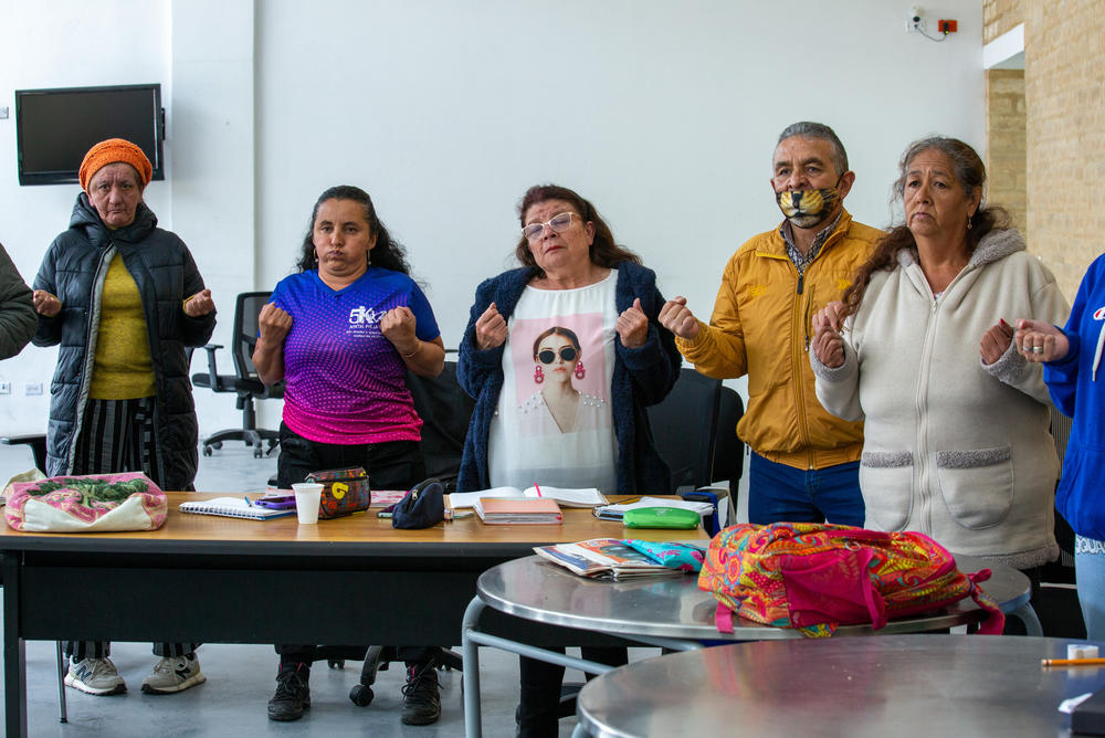 Rita Salamanca (centro), de 60 años, se estira y respira antes de empezar una clase de ciencias en la Manzana del Cuidado del barrio de San Cristóbal de Bogotá. Es una de las más de 12 000 mujeres de la ciudad que asisten a los cursos gratuitos ofrecidos. Sueña con obtener su diploma de secundaria.