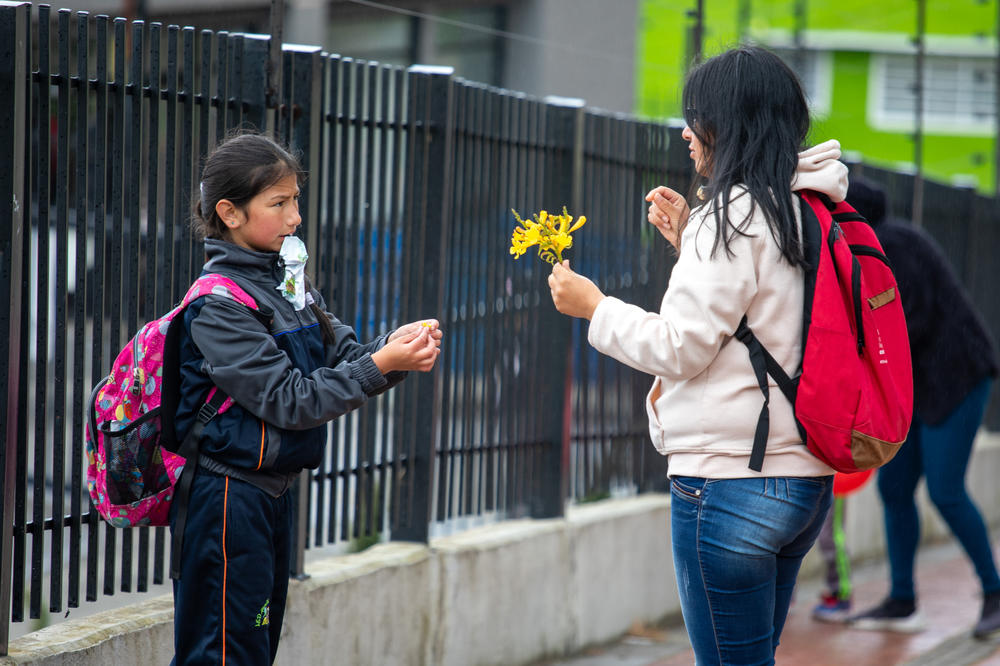 Infante y su hija Brigitte, de 9 años, se detienen a recoger flores en su camino de regreso a casa después del colegio. El día de Infante empieza a las 5 de la mañana y no termina hasta la hora de dormir.