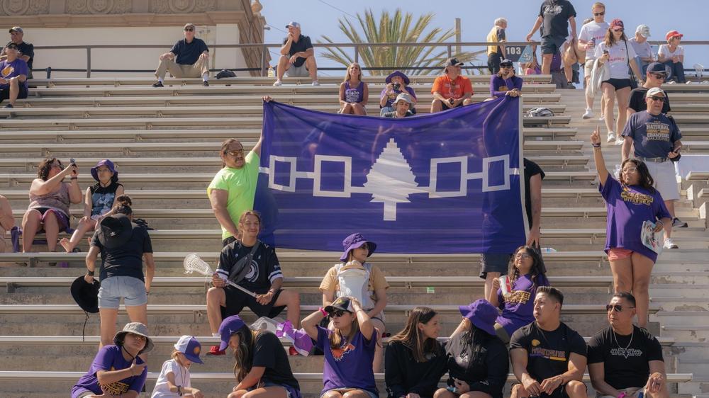 Supporters hold up a banner displaying the Haudenosaunee Confederacy as they cheer for the Haudenosaunee Nationals during a July 23, 2023 match against England in San Diego, Calif.