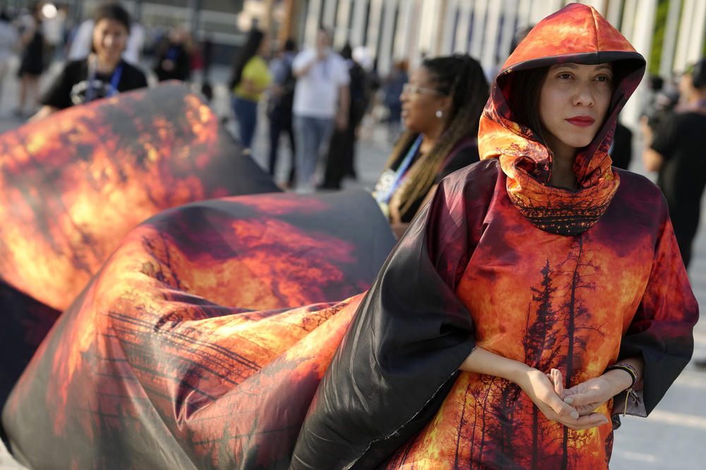 Islene Facanha, of Portugal, participates in a demonstration dressed with images of wildfires at the COP28 U.N. Climate Summit.