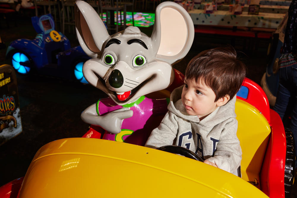 Elliot Gonzalez enjoys a ride with Chuck E. Cheese. Digital cards have replaced game tokens at the pizza-arcade chain.