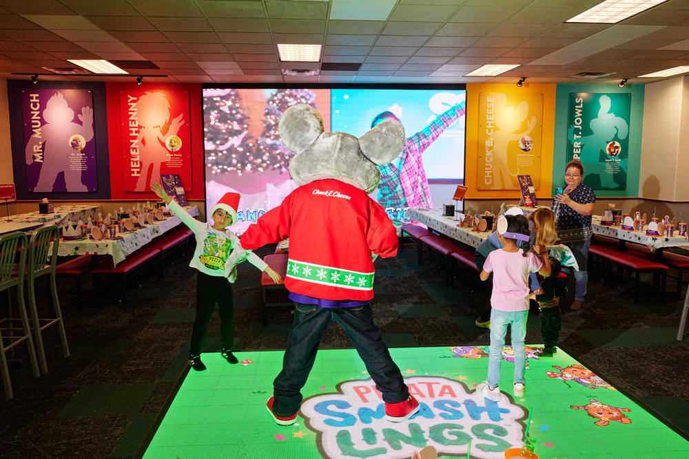 The Chuck E. Cheese mascot shows kids how to do the 