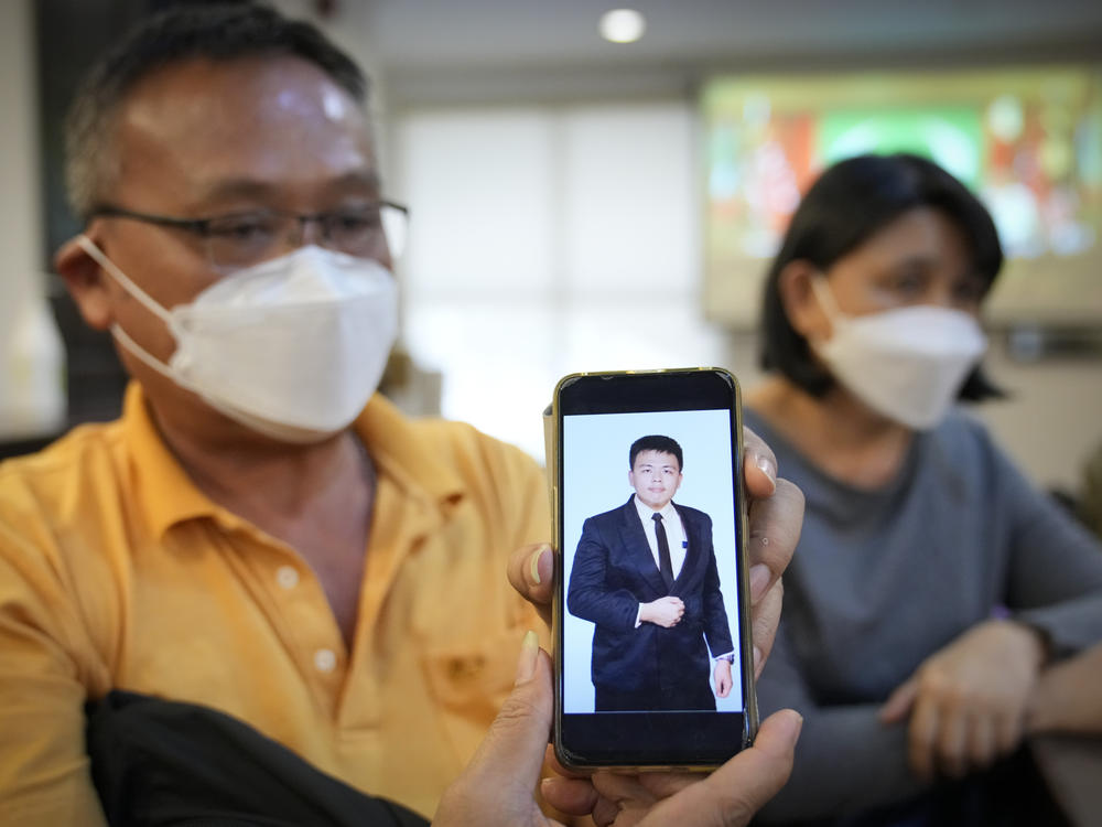 Goi Chee Kong shows a picture of his son Goi Zhen Feng, who died after falling prey to human trafficking, during a press conference in Petaling Jaya, Malaysia, on Sept. 21, 2022. Goi said he believed his 23-year-old son was forced to work for groups involved in online scams.