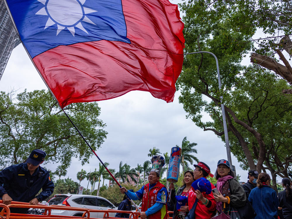 A supporter of Kuomintang, or KMT, Taiwan's major opposition party, waves Taiwan's national flag on Nov. 24, 2023, in Taipei, Taiwan. Researchers uncovered an influence operation targeting Taiwan's upcoming presidential election on Facebook, TikTok and YouTube.