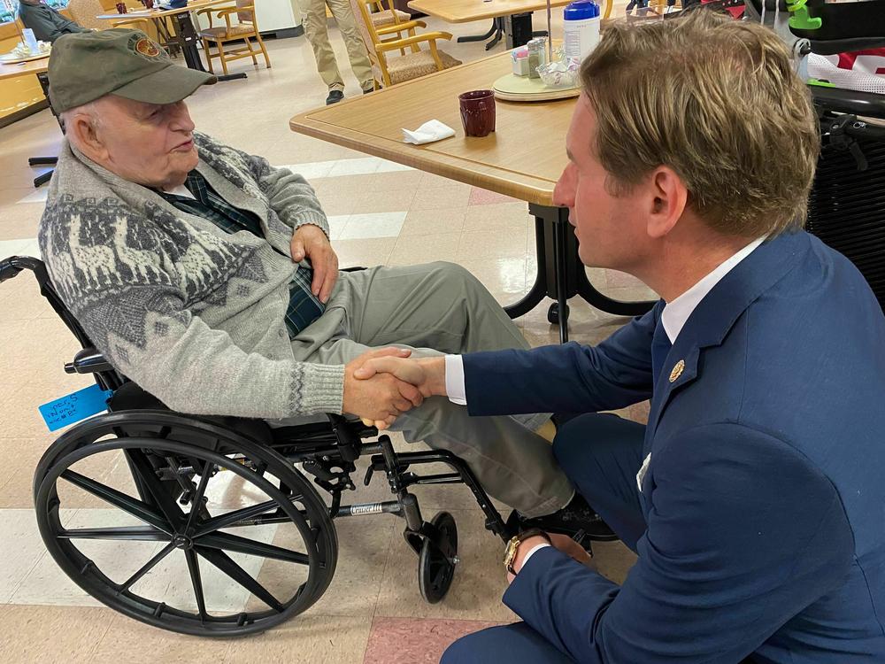 Stanley Piper talks with Rep. Dean Phillips, D-Minn., at the New Hampshire Veterans Home in Tilton, N.H. on Dec. 8, 2023.