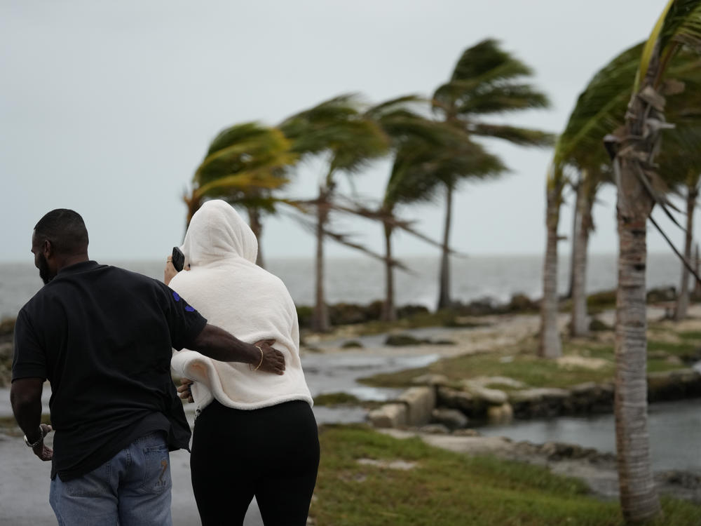 Local resident Wayne Cox and friend Irma Parrilla, visiting from Orlando, brave gusty winds and drizzling rain to visit Matheson Hammock Park in Coral Gables, Fla., on Friday.