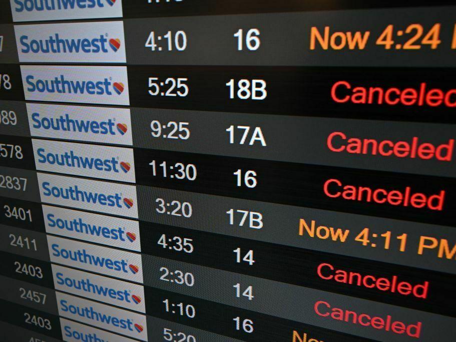 A digital display shows cancelled flights in the Southwest Airlines luggage area at Los Angeles International Airport in December 2022.