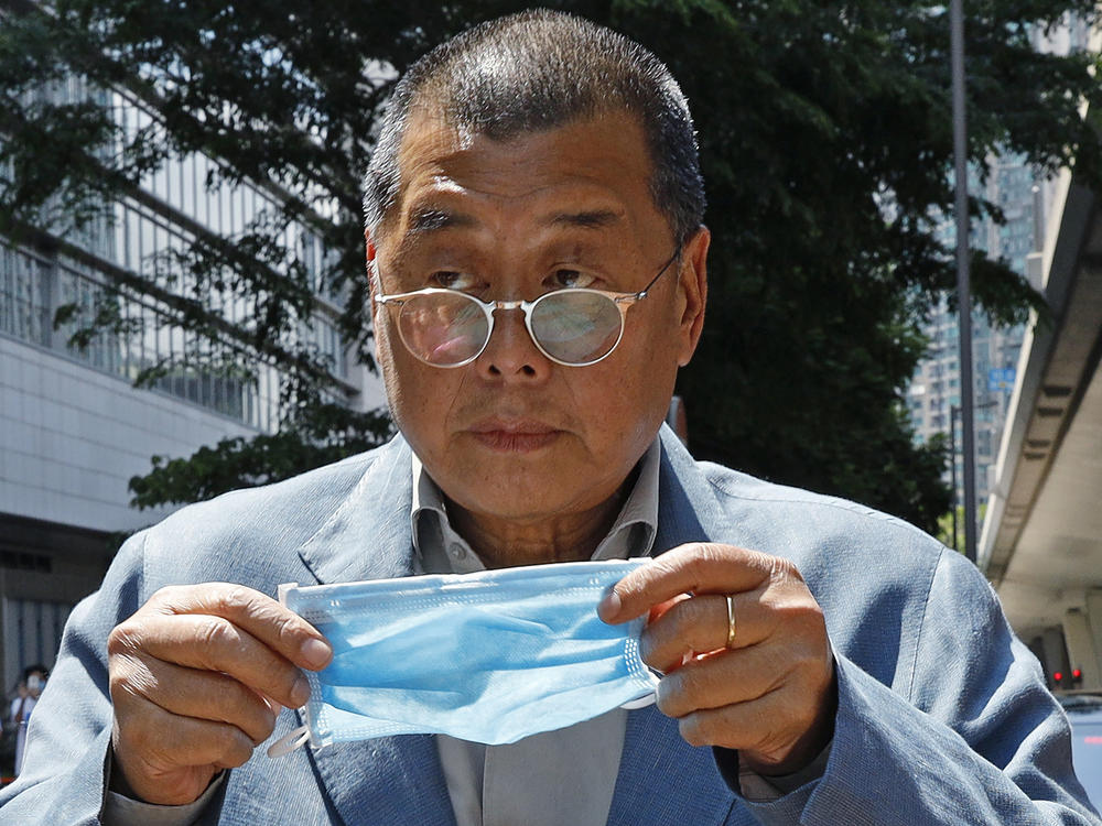 Hong Kong media tycoon Jimmy Lai, who founded local newspaper Apple Daily, prepare to put on a face mask before entering a court in Hong Kong on May 5, 2020.