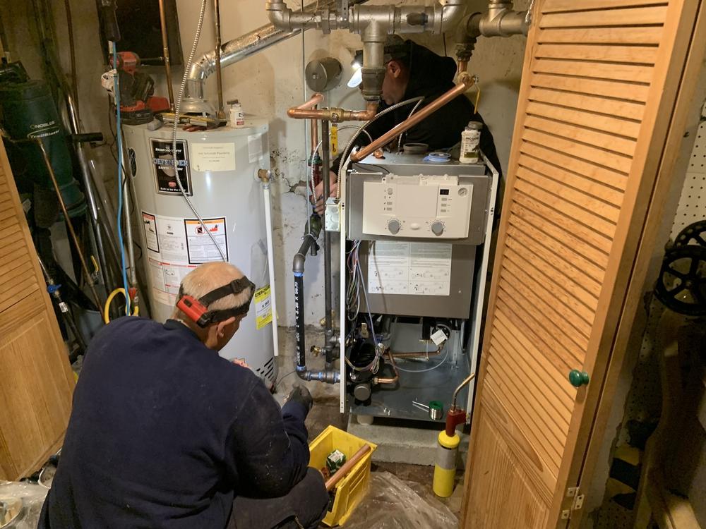 Oval Heating and A/C workers install a more efficient condensing gas boiler in a Sharon Hill, Pennsylvania home. New Department of Energy efficiency standards can only be met with these boilers or furnaces, which save customers about 15% on their gas utility bill.
