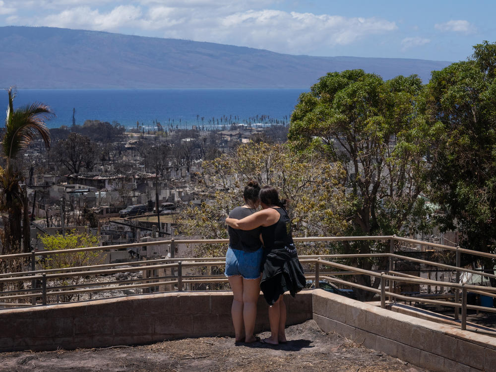 Two women embrace and cry as they look out over Lahaina, in Maui, Hawaii, which was severely damaged by a wildfire in August.