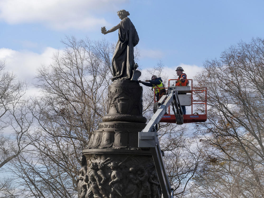 Workers prepare a Confederate memorial for removal in Arlington National Cemetery on Monday.