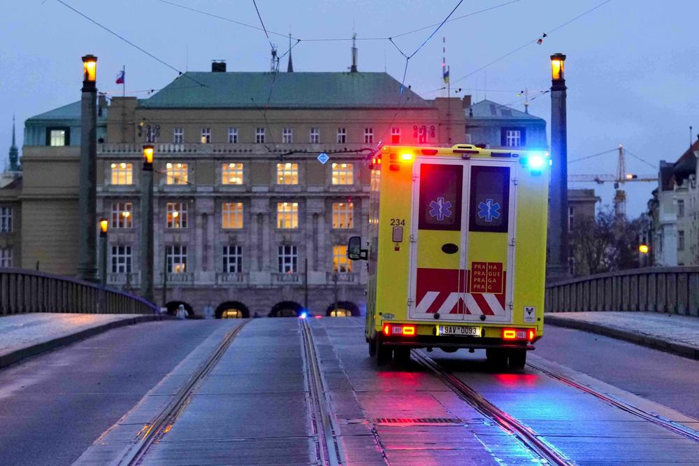 An ambulance drives towards the building of Philosophical Faculty of Charles University in downtown Prague on Thursday after a deadly shooting.