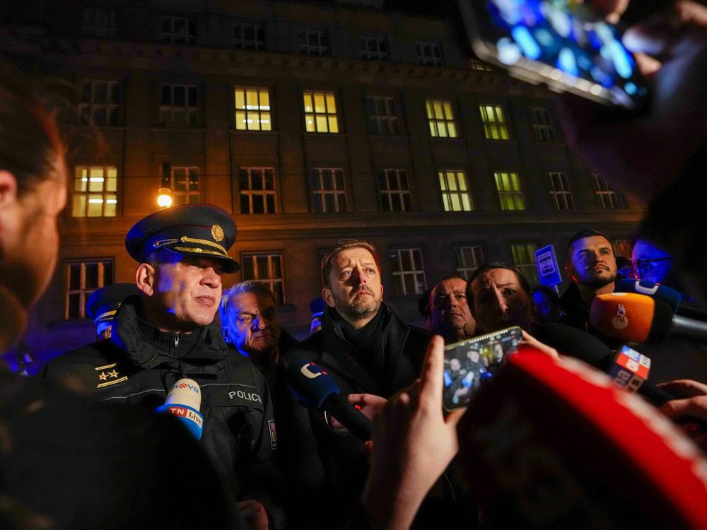 Czech Interior Minister Vit Rakusan (center) and Prague Police Chief Martin Vondrasek (left) speak to the media after a mass shooting in downtown Prague on Thursday.