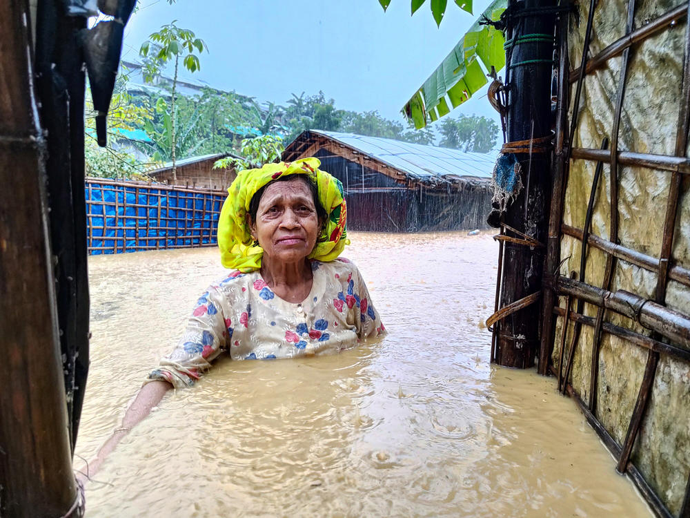 A Rohingya woman stands in chest-deep water during a 2021 flood. The refugee camp in Bangladesh is prone to natural disasters including floods, fires and landslides.