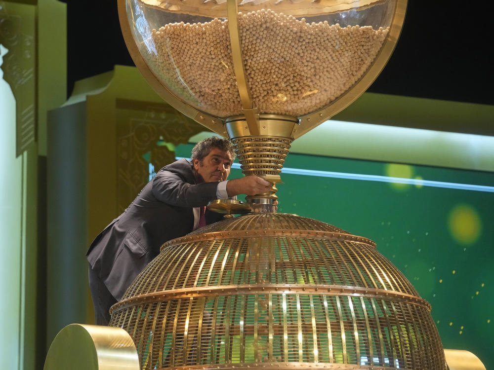 A workers supervises the moment when lottery balls are filled into a drum before the draw at Madrid's Teatro Real opera house during Spain's bumper Christmas lottery draw known as El Gordo, or The Fat One, in Madrid, Spain, Friday, Dec. 22, 2023.