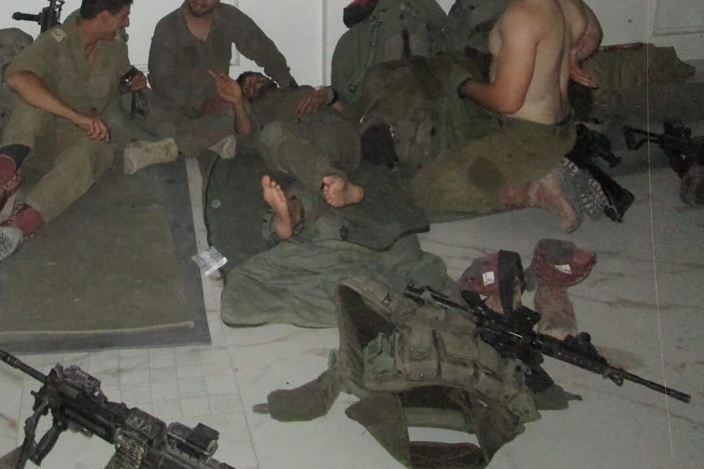 Alon Keren (left) and soldiers from his commando unit sleep on the floor of an evacuated Palestinian home in Gaza.