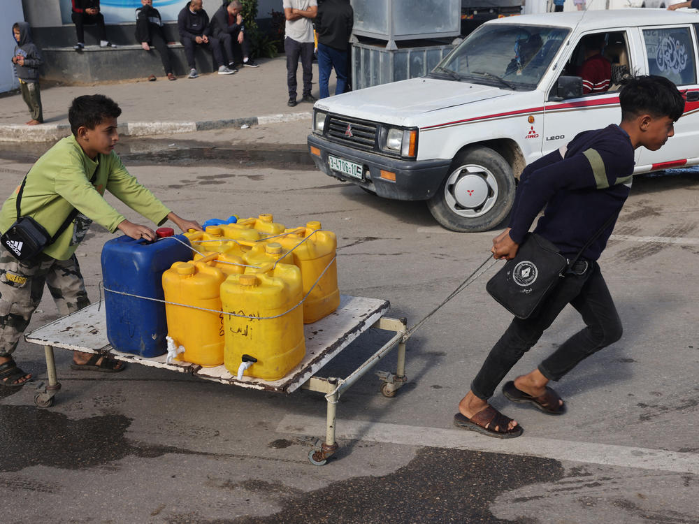 Internally displaced Palestinian children use a makeshift wheeled cart to haul water in Rafah in the southern Gaza Strip on Sunday, as battles continue between Israel and the militant group Hamas.