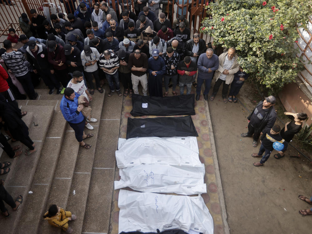 Palestinians pray near the wrapped bodies of relatives killed in the Israeli bombardment of the Gaza Strip, outside a morgue in Khan Younis on Wednesday.