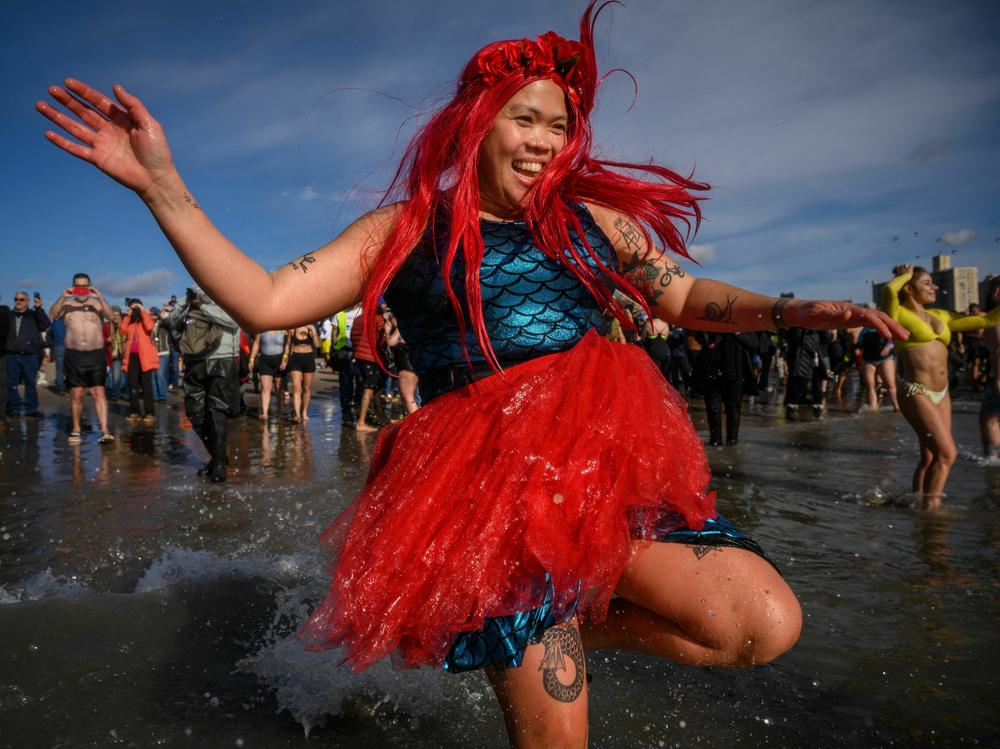 A mermaid takes the annual polar bear plunge at Brooklyn's Coney Island beach last year. More people take cold plunges on a regular basis for health benefits, but hype outpaces research for now.