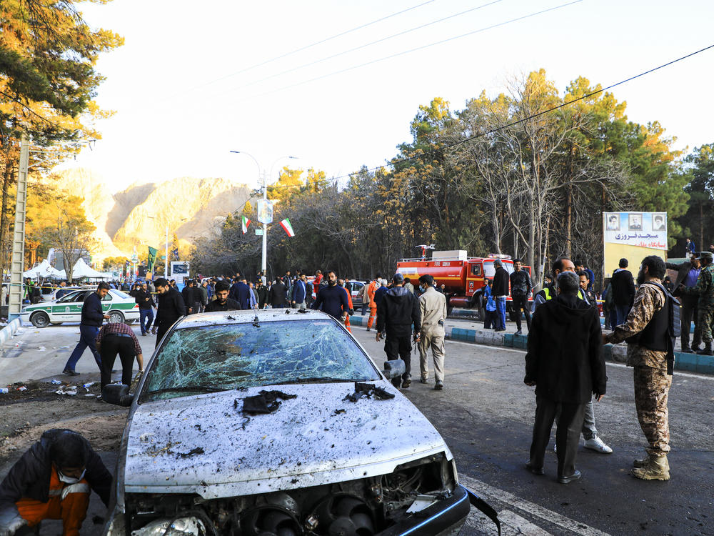 People gather at the site of an explosion in the city of Kerman, about 510 miles southeast of the capital Tehran, Iran, on Wednesday. Two bombs exploded at a commemoration for a prominent Iranian general slain by the U.S. in a 2020 drone strike, Iranian officials said.