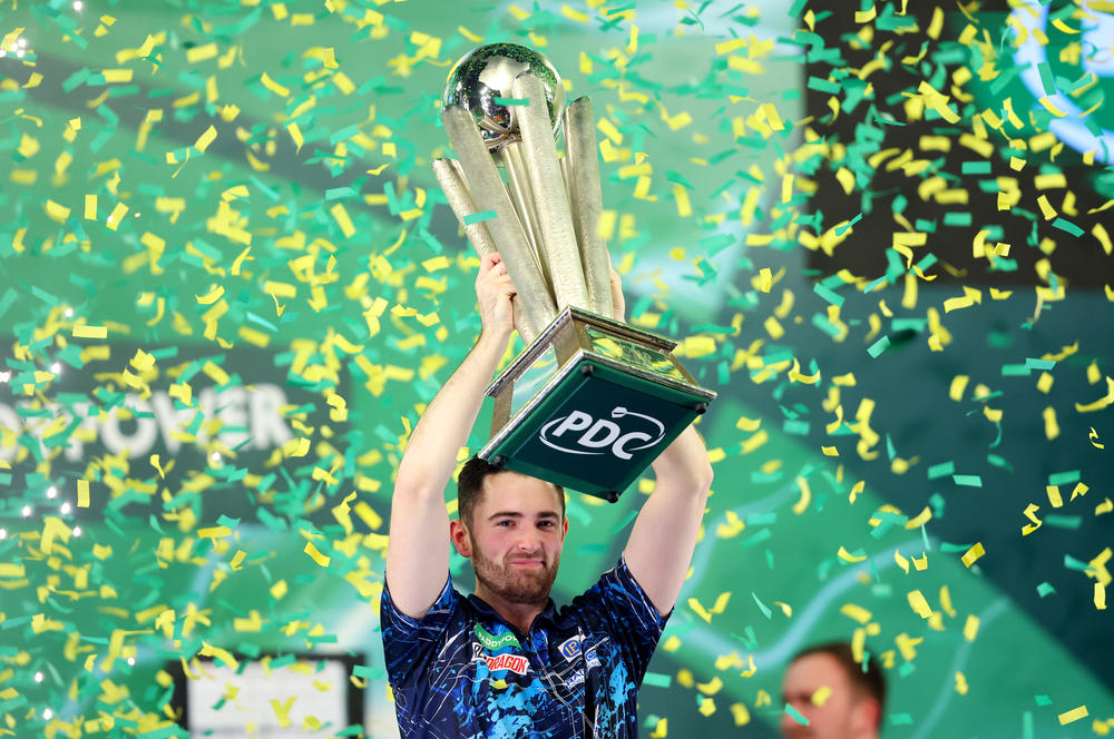 Luke Humphries of England lifts the trophy after winning the 2023/24 Paddy Power World Darts Championship Final against Luke Littler of England, at Alexandra Palace in London, Wednesday.