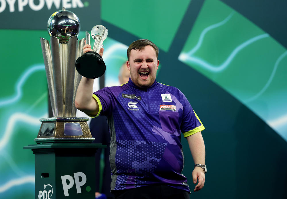 Runner-up Luke Littler of England celebrates with his trophy after the World Darts Championship final in London, Wednesday.