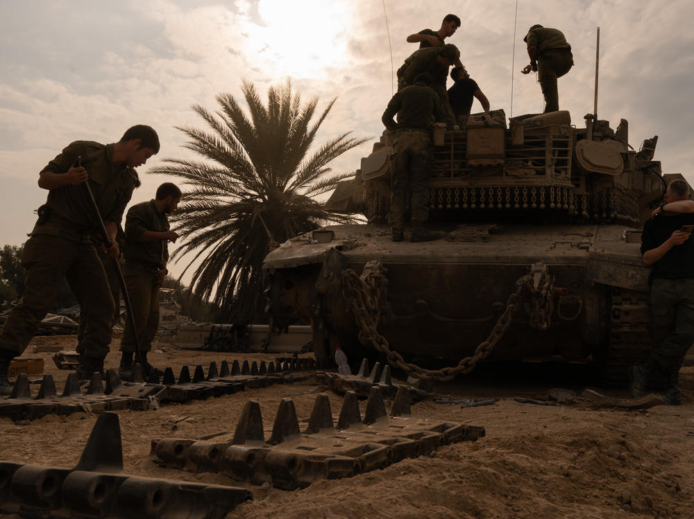 Israeli soldiers work on artillery after coming out of Gaza and across the border into Israel on Dec. 28, 2023.