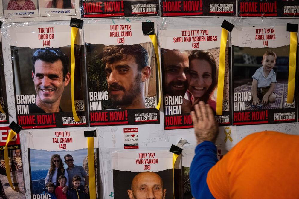 A man touches a wall with images of people who were kidnapped on Oct. 7, some of whom have been released from captivity, at a rally calling for the release of the remaining hostages in Tel Aviv, Israel, on Dec. 2.