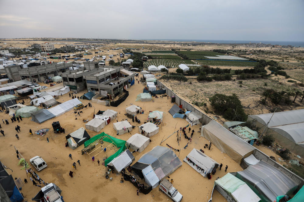 Displaced Palestinians along with makeshift tents are seen on Dec. 21 in an area that Israel designated as a safe zone in al-Mawasi, Rafah, Gaza.